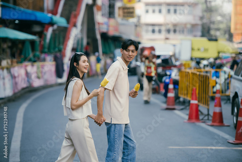 Young happy Asian couple tourist backpackers enjoy traveling in the local market.