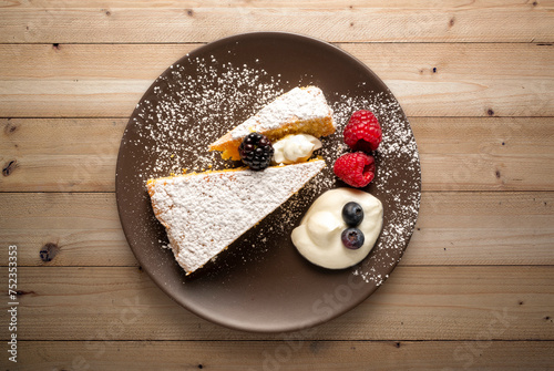 plate with slice of cake with fruits over wooden table
