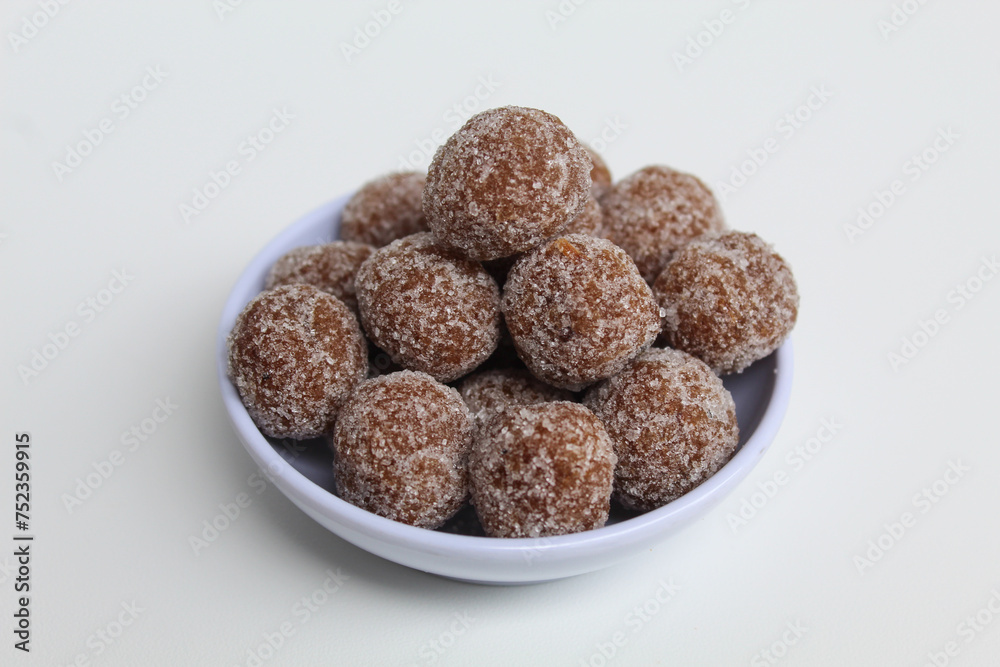 Tamarind candy balls in white bowl. Isolated on white background Tamarind candy balls in white bowl. Isolated on white background