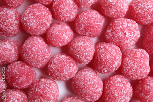 Background texture of soursop candy, in pink color and ball shaped, coated by sugar. Flat lay or top view photo