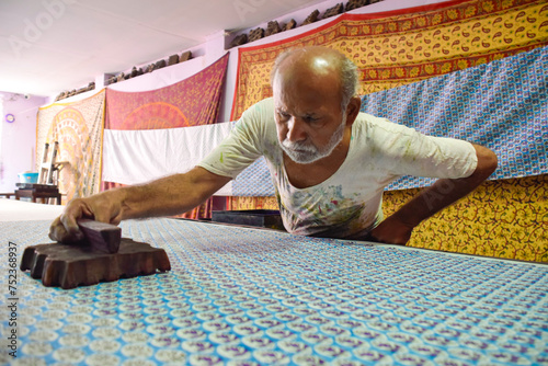 Artisan stamping patterns in ink on traditional Indian textiles as colorful sari