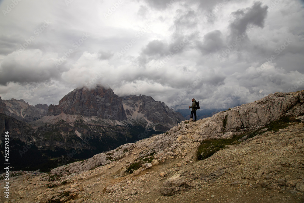 Man traveler traveling alone in breathtaking landscape of Dolomites Mounatains. Travel lifestyle wanderlust adventure concept.