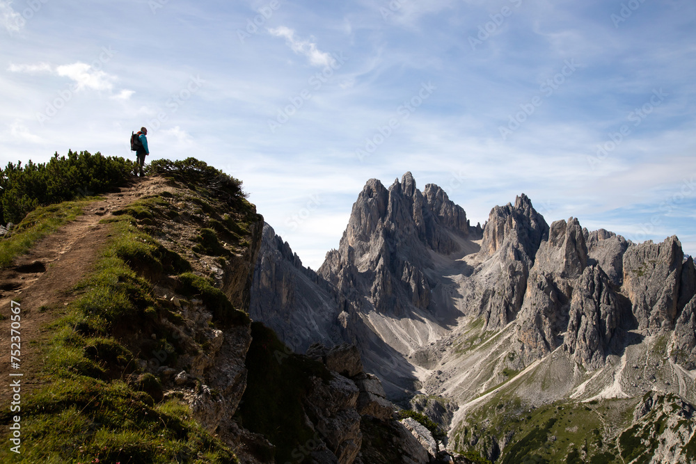 Fototapeta premium Stunning view of a tourist on the top of a hill enjoying the view of the Cadini di Misurina