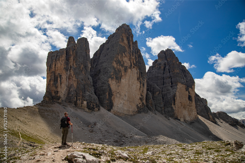 Stunning view of a tourist enjoying the view of the Tre Cime Di Lavaredo, Dolomites, Italy.