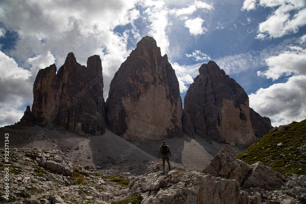 Stunning view of a tourist enjoying the view of the Tre Cime Di Lavaredo, Dolomites, Italy.