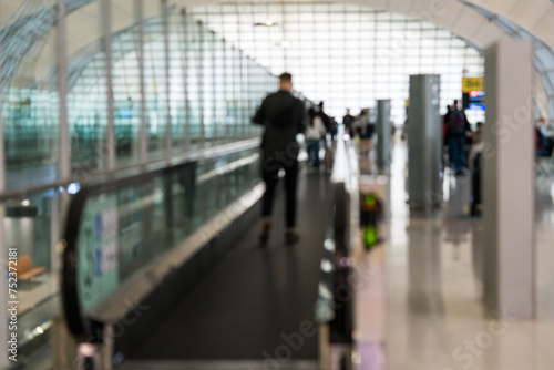 Blurred background of people walking on walkway at the airport. Abstract blur for background