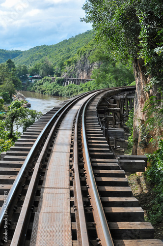 Tham Krasae Pass. A huge wooden trestle supports the tracks on a cliff bordered on one side by the mountain and on the other by the River Kwai