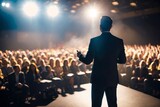 motivational speaker standing on stage in front of audience for motivation speech