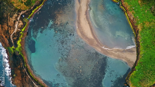Drone amazing turquoise lagoon on summer day. Calm water washing wild shore