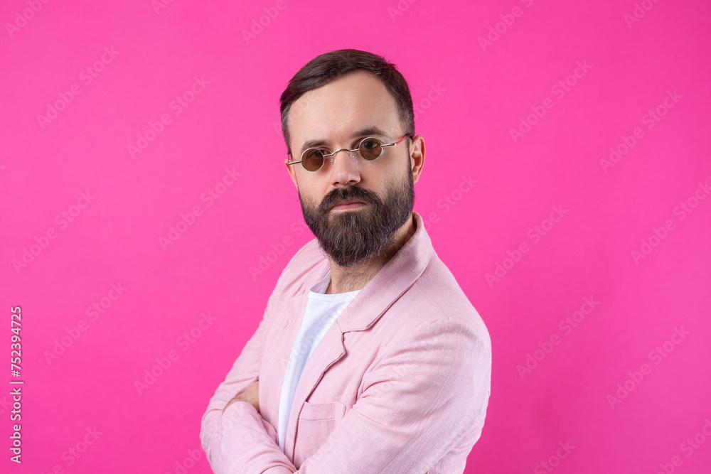 Obraz premium Bearded man dressed in a pink jacket with glasses. Emotional studio portrait.
