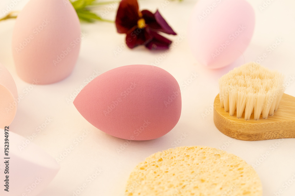 Beauty blender, beauty sponge on a beige background. Bright sponges for make-up cosmetics, a wooden brush for face massage. Makeup products. Beauty concept. Place for text.