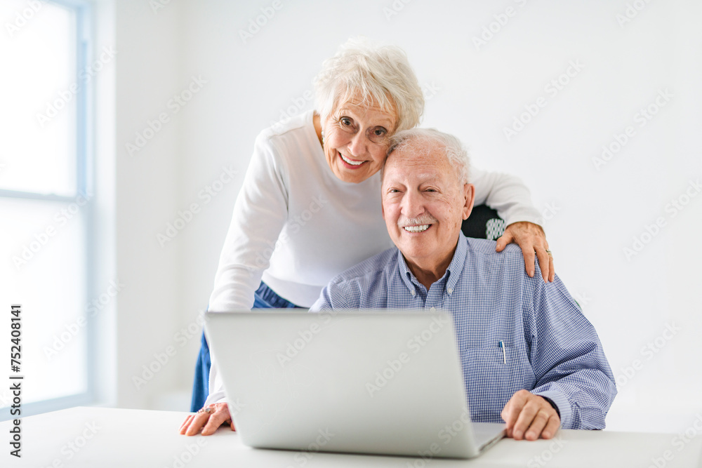 senior couple using a laptop while sitting at the office