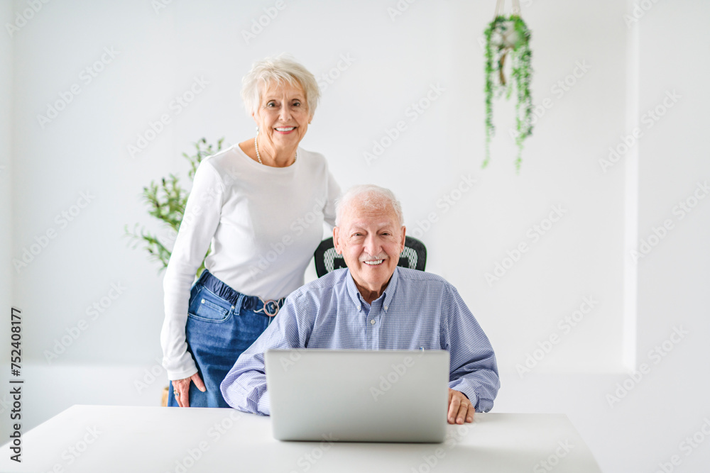 senior couple using a laptop while sitting at the office