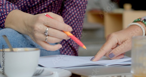 Woman hands close-up. Personal coaching or life coaching process. Woman trained coach works with individual to help set and achieve personal or professional goals on paper, pointing finger close-up 