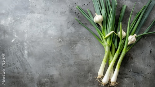 Sweet garleek - a mixture of spring onions and garlic cloves neatly arranged on a light concrete background, space for text, perfect for food and culinary themes. photo