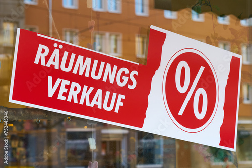 Schild mit der deutschen Aufschrift Räumungsverkauf vor Geschäftsschließung an einem Schaufenster photo