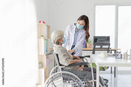 Asian doctor talk with old female patient about disease symptom, doctor use stethoscope listening lung of patient, elderly health check up , they wear surgical mask in hospital, corona virus 