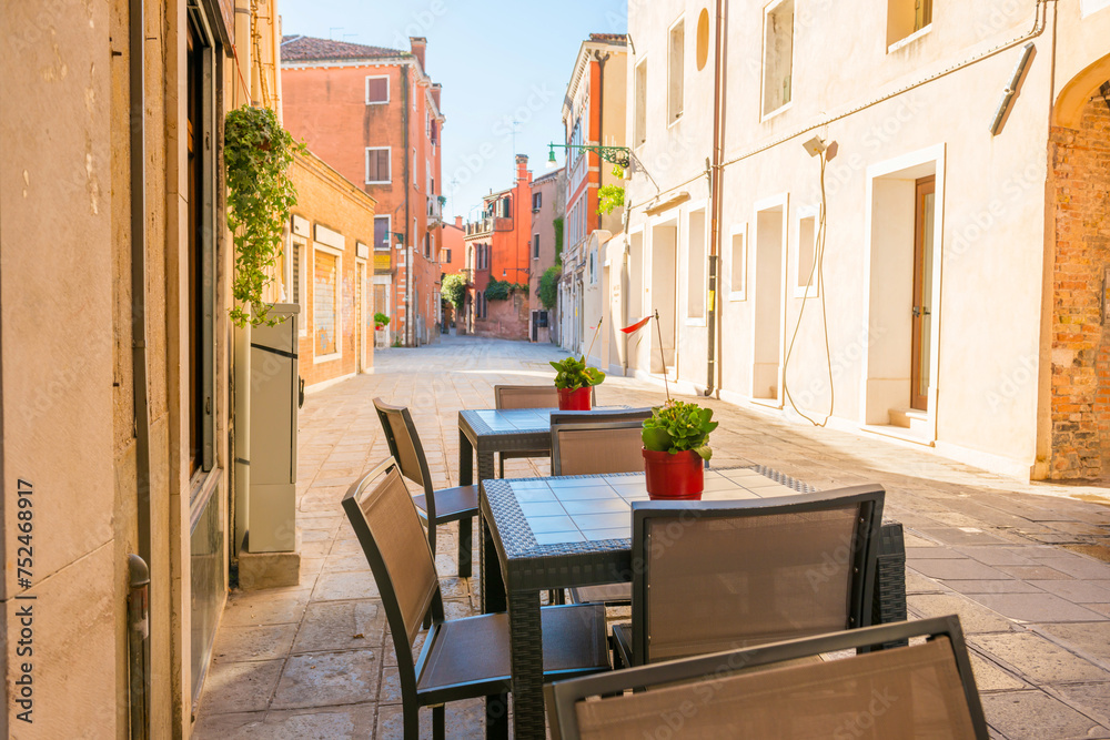 Obraz premium Outdoor cafe in old Venice street with colorful buildings