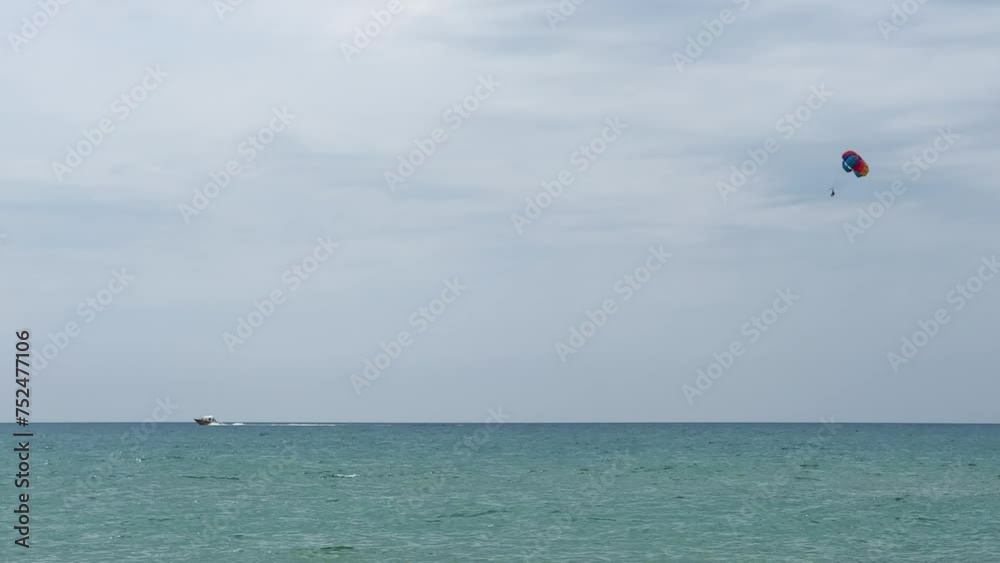 Parasailing: a boat with a marine parachute on the waves. The concept of a cloudy landscape, freedom and summer. Parachutists over the surface of the Black Sea against the sky on a summer day. 4K Parasailing: a boat with a marine parachute on the waves. The concept of a cloudy landscape, freedom and summer. Parachutists over the surface of the Black Sea against the sky on a summer day. 4K