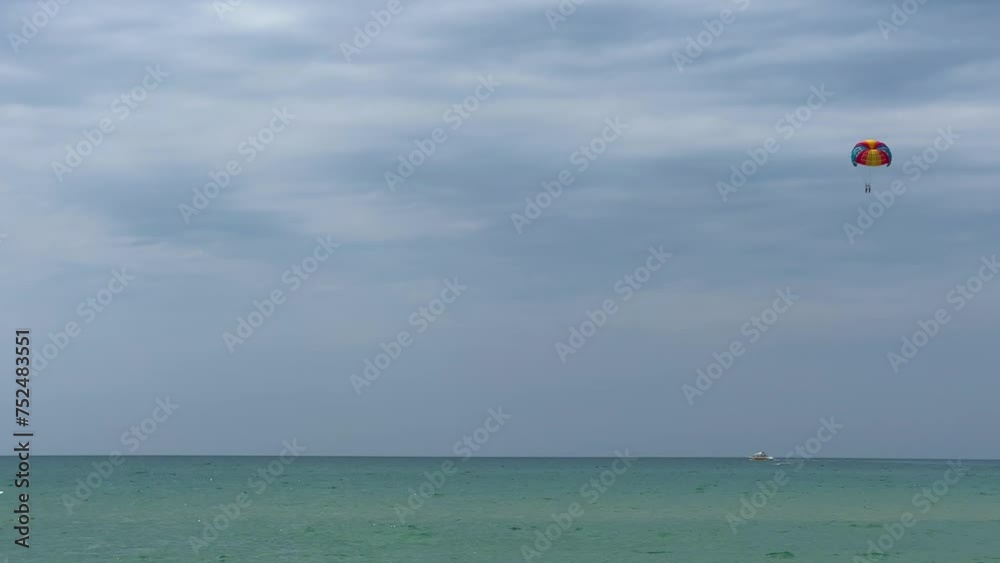 Parasailing: a boat with a marine parachute on the waves. The concept of a cloudy landscape, freedom and summer. Parachutists over the surface of the Black Sea against the sky on a summer day. 4K Parasailing: a boat with a marine parachute on the waves. The concept of a cloudy landscape, freedom and summer. Parachutists over the surface of the Black Sea against the sky on a summer day. 4K