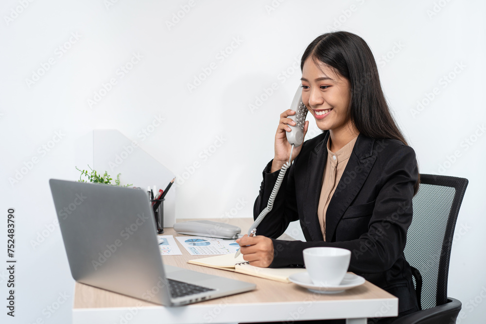 Business woman is receiving call with client to talking about investment of new business and taking notes on notebook Business woman is receiving call with client to talking about investment of new business and taking notes on notebook
