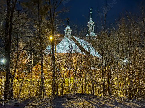 Old wooden church dedicated to St. Trinity Church in Koszecin, Poland. View at night photo