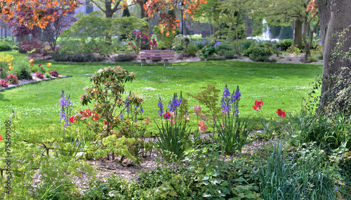flower bed in a public park landscaped in front of a grassy space in spring