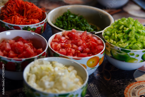 Chopped vegetables - peppers, onions, carrots, tomatoes in separate plates