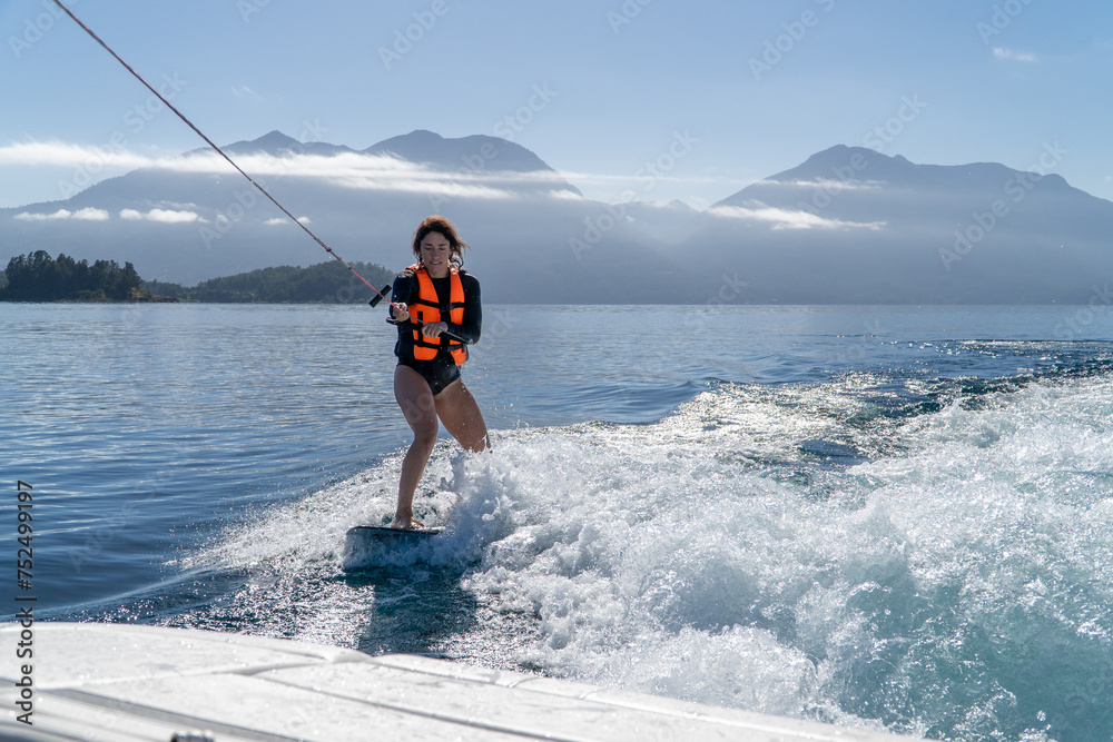 Woman in her 30s learning wake boarding in the lake.