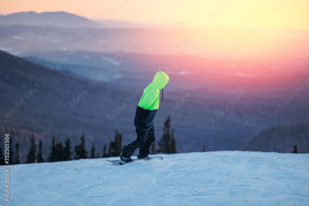 Man snowboarder rides through snow, explosion. Freeride snowboarding in Sheregesh Ski Resort on background snowy forest with sunlight