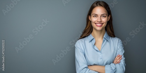 Happy young smiling confident professional business woman wearing blue shirt, pretty stylish female executive looking at camera, standing arms crossed isolated on gray background