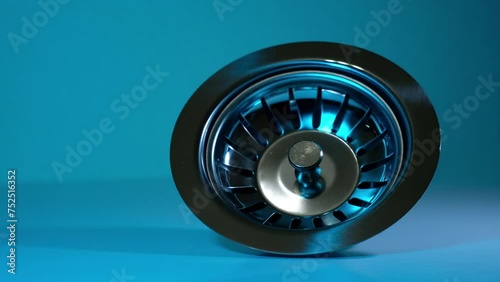 drain of a washbasin with strainer on blue background