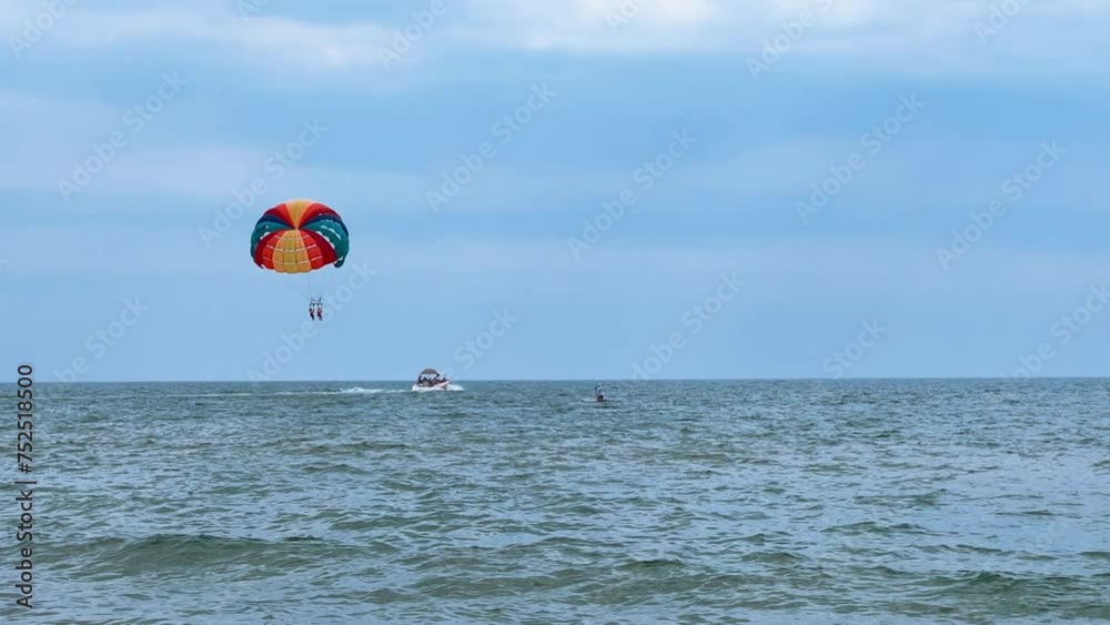 Parasailing: a boat with a marine parachute on the waves. The concept of a cloudy landscape, freedom and summer. Parachutists over the surface of the Black Sea against the sky on a summer day. 4K Parasailing: a boat with a marine parachute on the waves. The concept of a cloudy landscape, freedom and summer. Parachutists over the surface of the Black Sea against the sky on a summer day. 4K