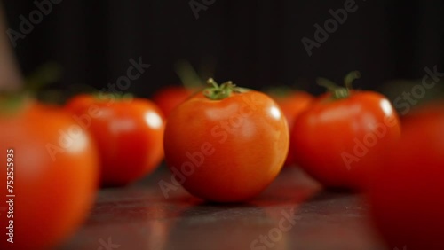 A slow-motion video of a tomato rotating on a table among others. Salad preparation, healthy eating, vegetarianism. High quality FullHD footage