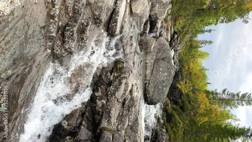 A beautiful waterfall in the autumn mountains beyond the Arctic Circle in the north, in Khibiny, Murmansk region. Panoramic view of a beautiful waterfall in the mountains in autumn, Kola Peninsula 4К photo