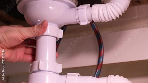 Repairing plumbing pipes under the kitchen sink