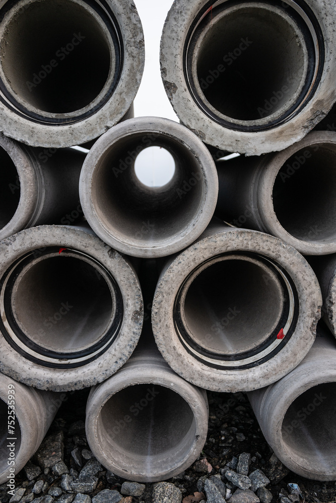 Large pile of concrete drain pipes at a construction site. Large pile of concrete drain pipes at a construction site.