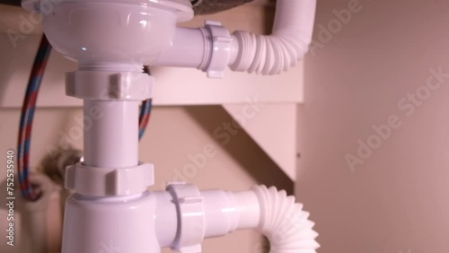 Repairing plumbing pipes under the kitchen sink