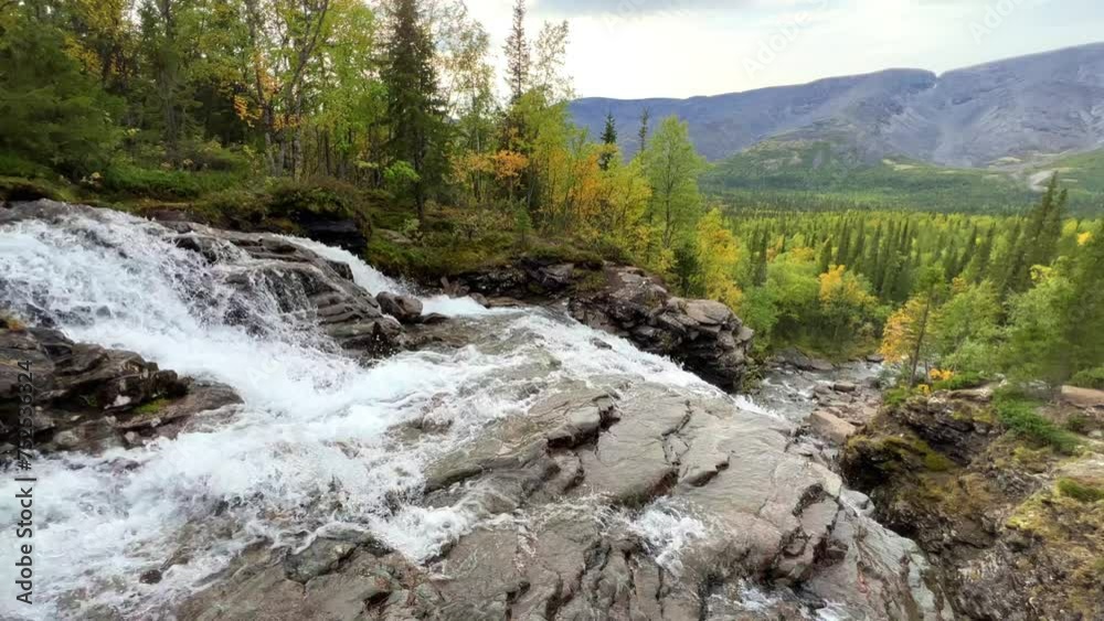 A beautiful waterfall in the autumn mountains beyond the Arctic Circle in the north, in Khibiny, Murmansk region. Panoramic view of a beautiful waterfall in the mountains in autumn, Kola Peninsula 4К A beautiful waterfall in the autumn mountains beyond the Arctic Circle in the north, in Khibiny, Murmansk region. Panoramic view of a beautiful waterfall in the mountains in autumn, Kola Peninsula 4К