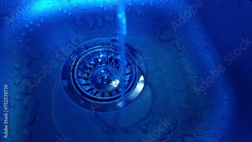 
Close-up of water pouring into a sink in the kitchen. Plumbing, faucet
