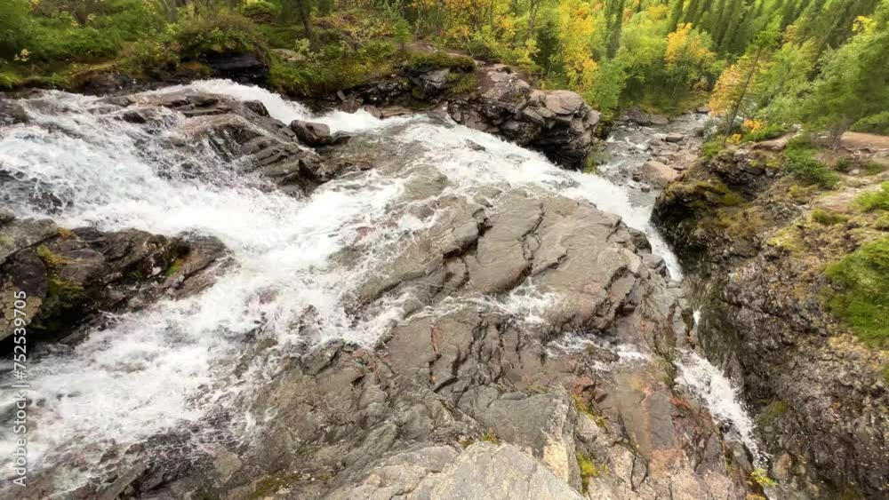 A beautiful waterfall in the autumn mountains beyond the Arctic Circle in the north, in Khibiny, Murmansk region. Panoramic view of a beautiful waterfall in the mountains in autumn, Kola Peninsula 4К A beautiful waterfall in the autumn mountains beyond the Arctic Circle in the north, in Khibiny, Murmansk region. Panoramic view of a beautiful waterfall in the mountains in autumn, Kola Peninsula 4К