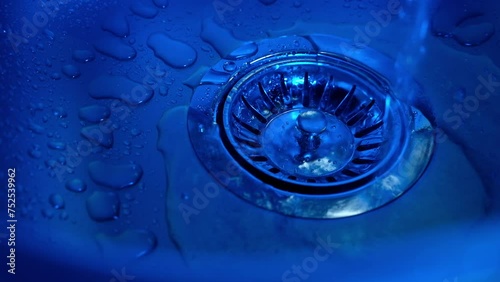 
Close-up of water pouring into a sink in the kitchen. Plumbing, faucet

