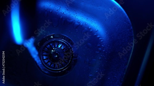 
Close-up of water pouring into a sink in the kitchen. Plumbing, faucet
