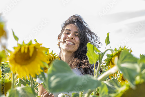 Jeune femme souriante dans un champs de tournesols