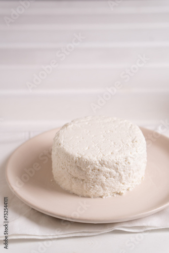 Homemade pressed cottage cheese lies on a light plate