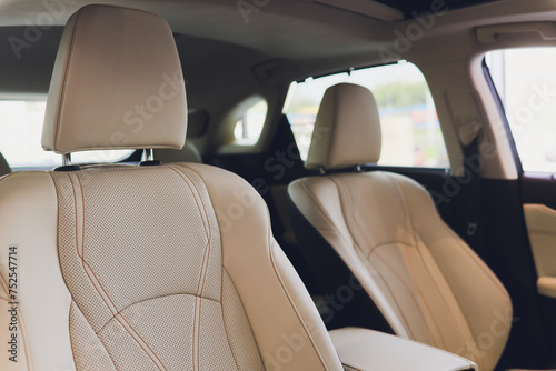 Car inside driver place. Interior of prestige modern car. Front seats with steering wheel dashboard. Beige cockpit with metal decoration panoramic roof on isolated white background.