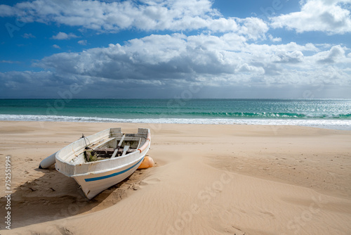 Fototapeta Naklejka Na Ścianę i Meble -  Abandoned Boat on a Secluded Sandy Beach with Cloudy Sky