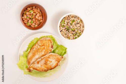 Grilled chicken in a plate with rice and beans isolated clean white background top view photo