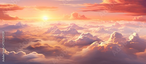 The painting depicts the view of a stunning sunset over a sky filled with fluffy clouds. The warm hues of the setting sun illuminate the clouds, creating a dramatic and colorful scene.