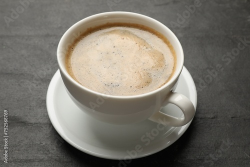 Cup of aromatic coffee on black table  closeup